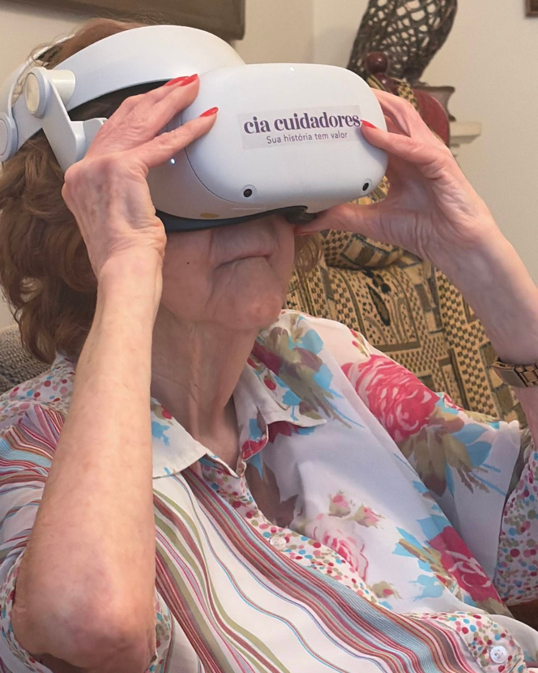 Pessoa idosa utilizando o óculos de realidade virtual da Cia Cuidadores em sua residência